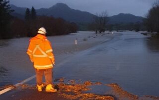traffic controller standing by flooded road