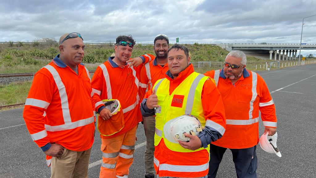 a group of road workers posing for a photo